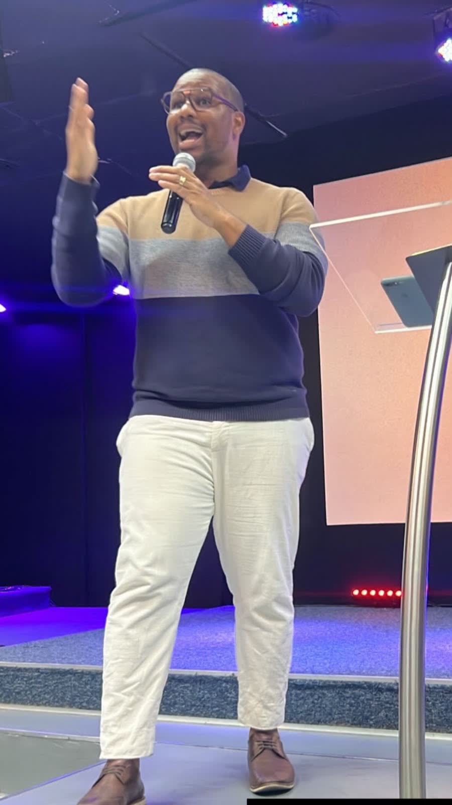 Vinícius falando no palco de um evento de correspondentes bancários